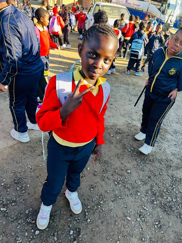 A pupil in school uniform on the school grounds