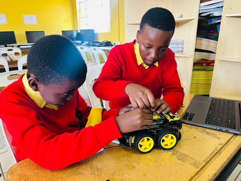 A pupil wiring a robot buggy in class